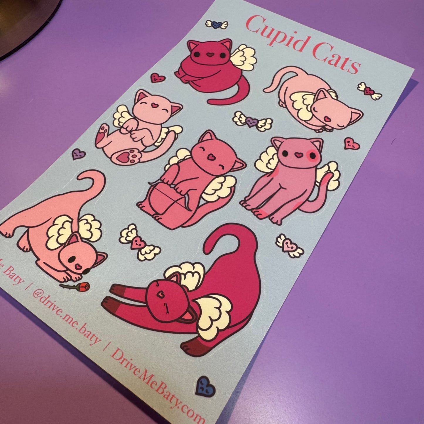 Sheet of Cupid Cats stickers with pink cats with wings on a purple background