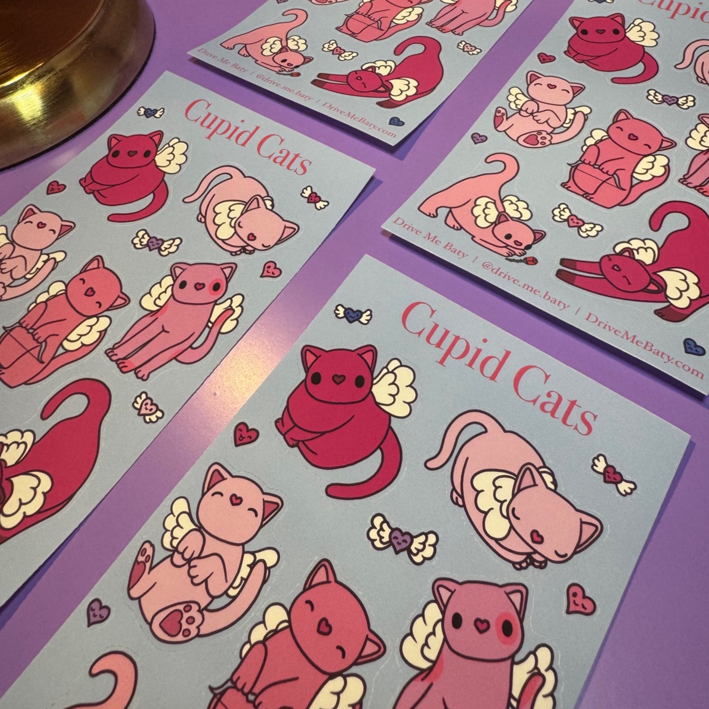 Sticker sheets with cupid cats design on a purple surface