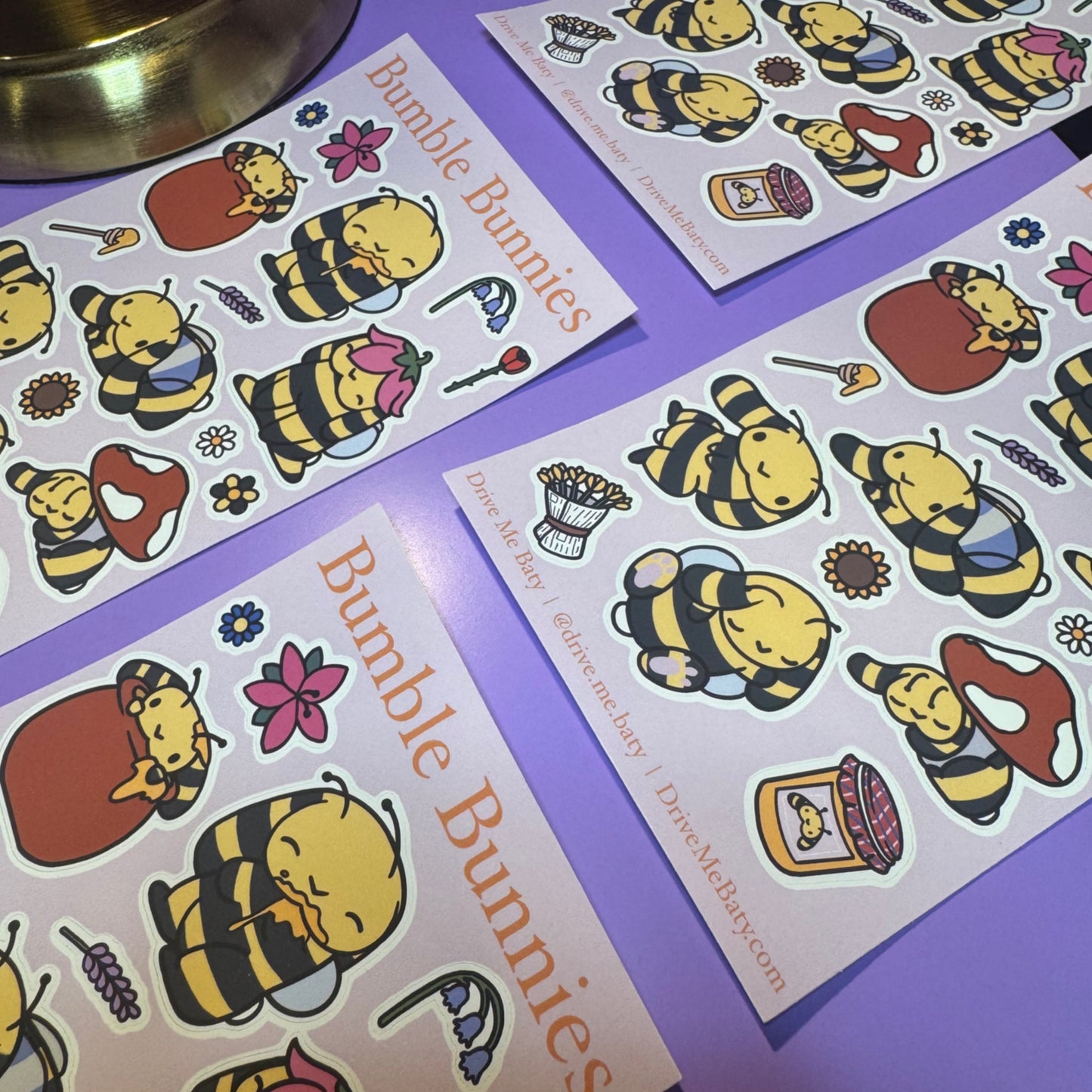 Sticker sheets with cartoon bee characters on a purple surface