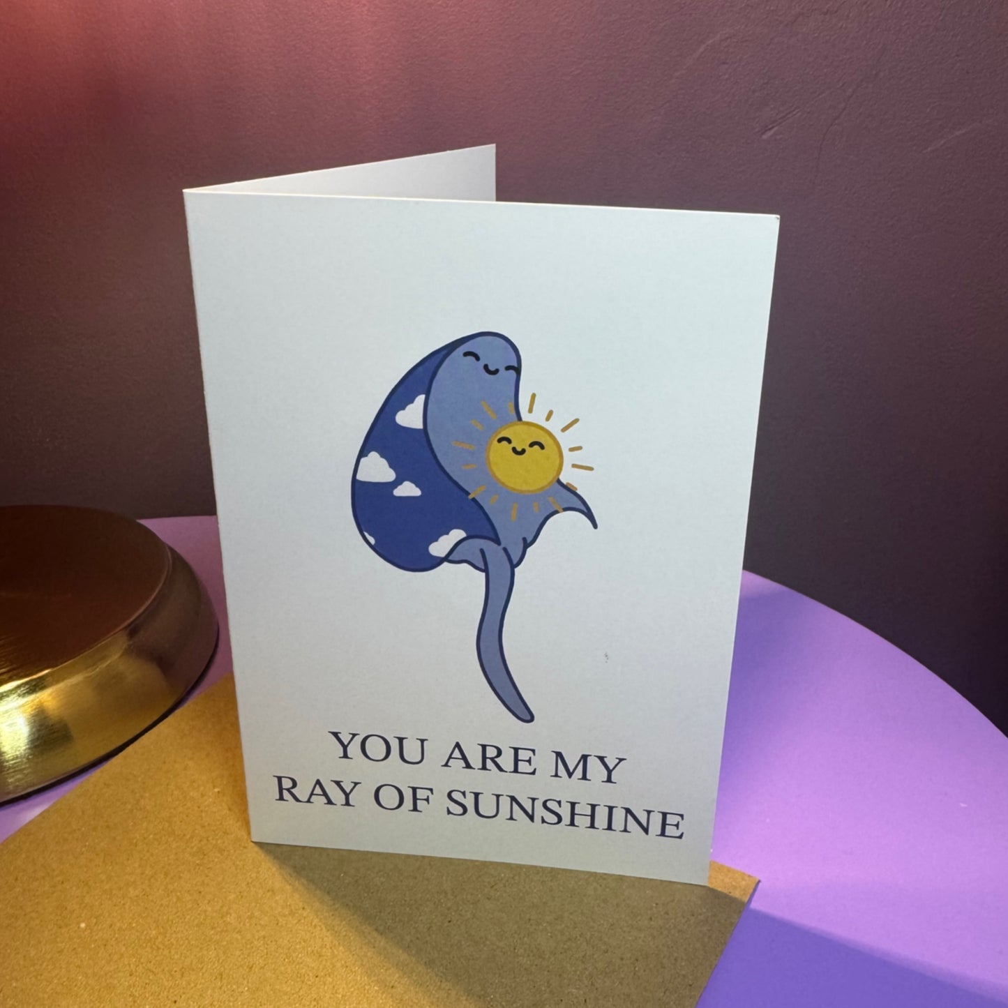 Greeting card with cartoon ray and sun design.