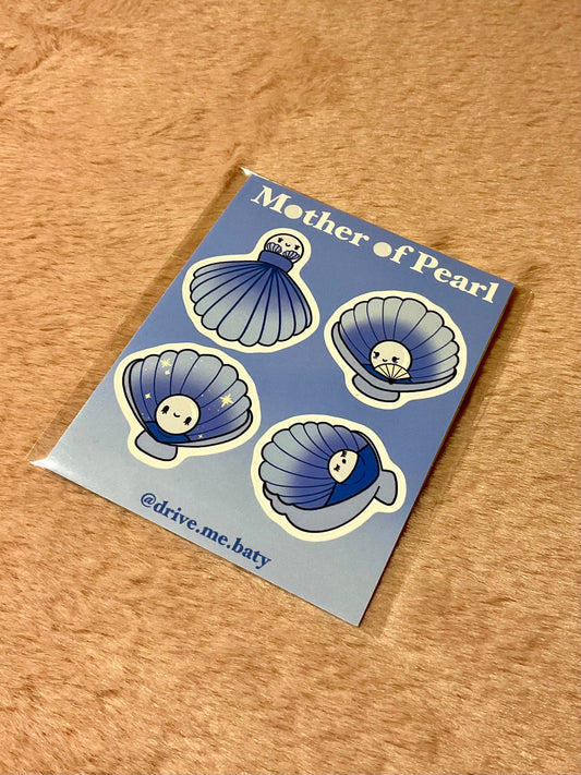 Photo of a small sticker sheet, Mother Of Pearl.
The sheet consists of four different designs of Sparkling White Pearls sat in Blue shells.
The first design shows a Pearl wearing a shell as a dress.
The second design shows a Pearl sat in her shell throne with a fan.
The third design shows a smiling pearl sat in her shell as if it was a chair.
The fourth design shows a Pearl sleeping, tucking into the shell as if it was a bed.